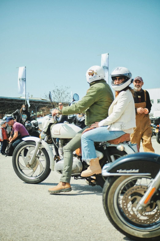 a couple riding motorcycles with people watching