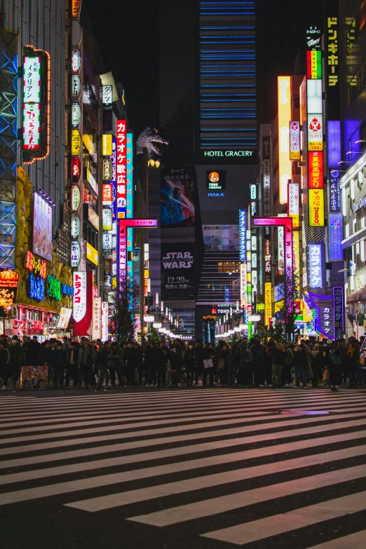 an intersection with pedestrians crossing the street at night