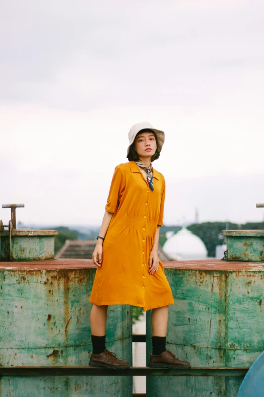 a person standing on a rail outside in a hat