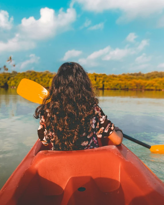 a person on the water in a boat with yellow oars