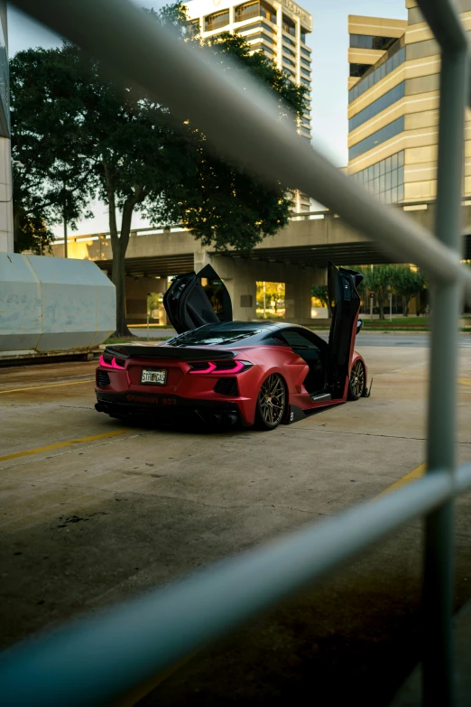 a car parked in a parking lot behind a chain link fence