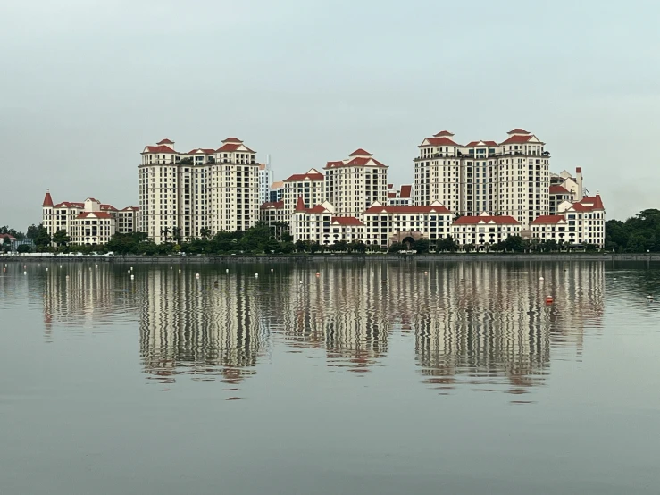 the water with several buildings near it is reflecting off of the surface