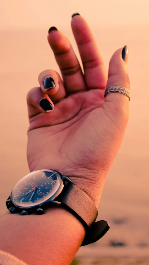 someone is holding out their wrist on the beach