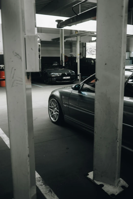 an older sports car is parked in a parking garage
