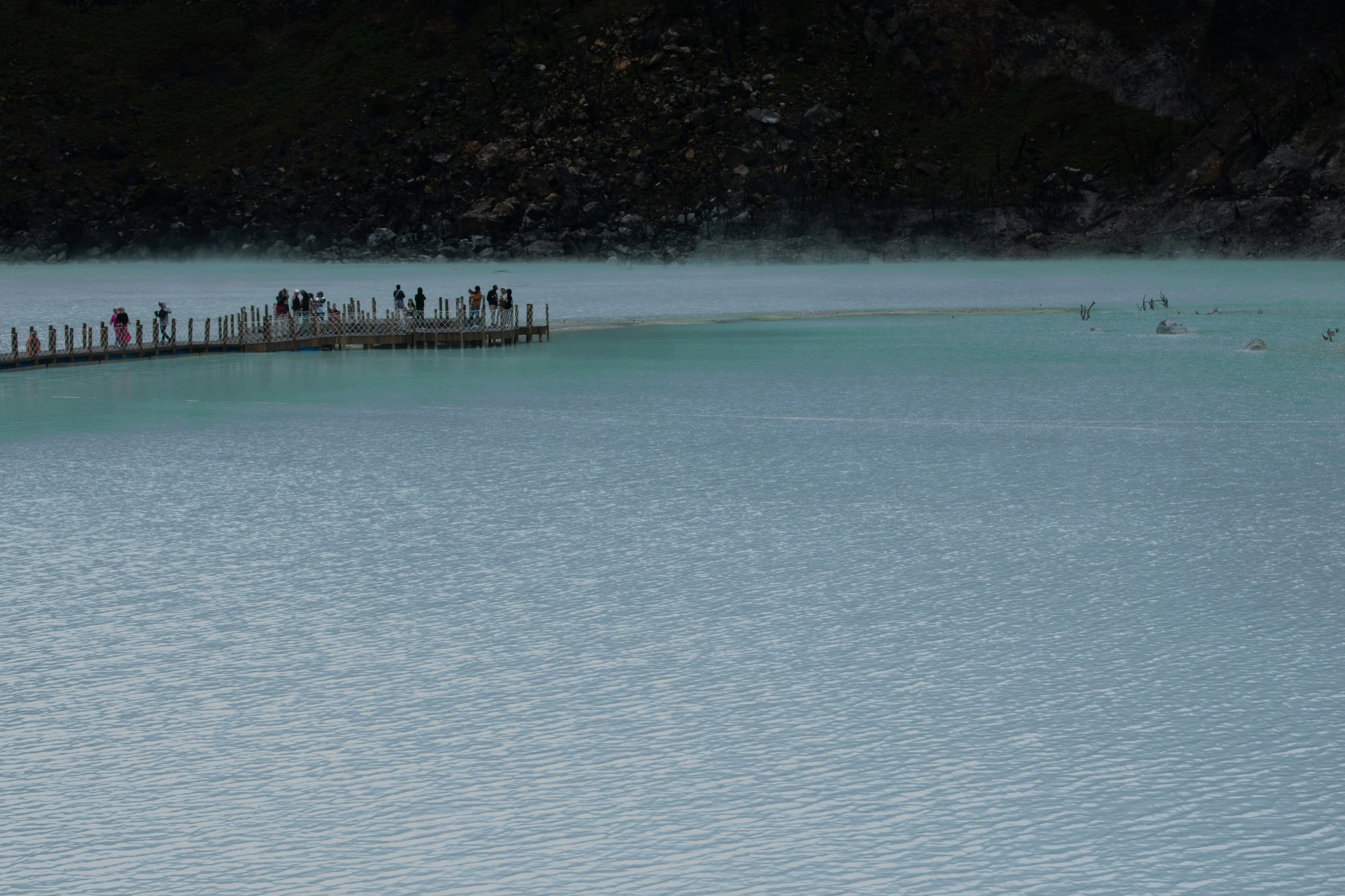 some people are standing on a pier over a lake