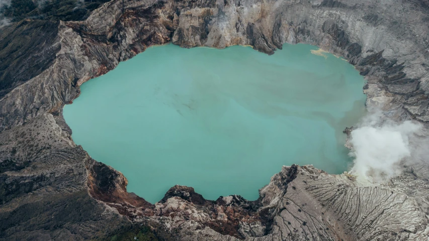 a blue lake surrounded by a mountain in the middle