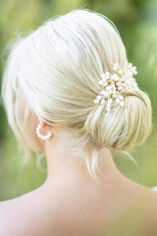 a woman is wearing a hair comb that has pearls