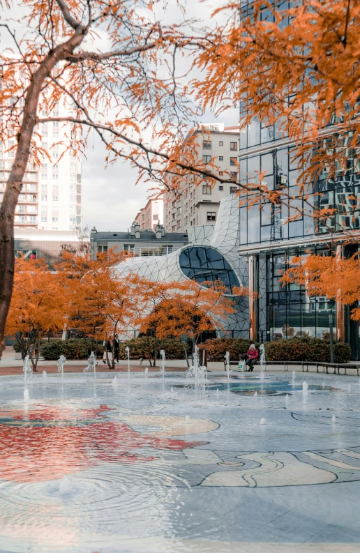 some red trees trees and a building and a body of water