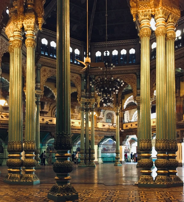 large round gold columns standing next to each other in a very ornate building