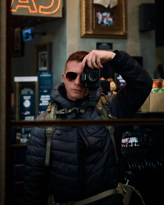 a man taking a po of himself in front of a cafe