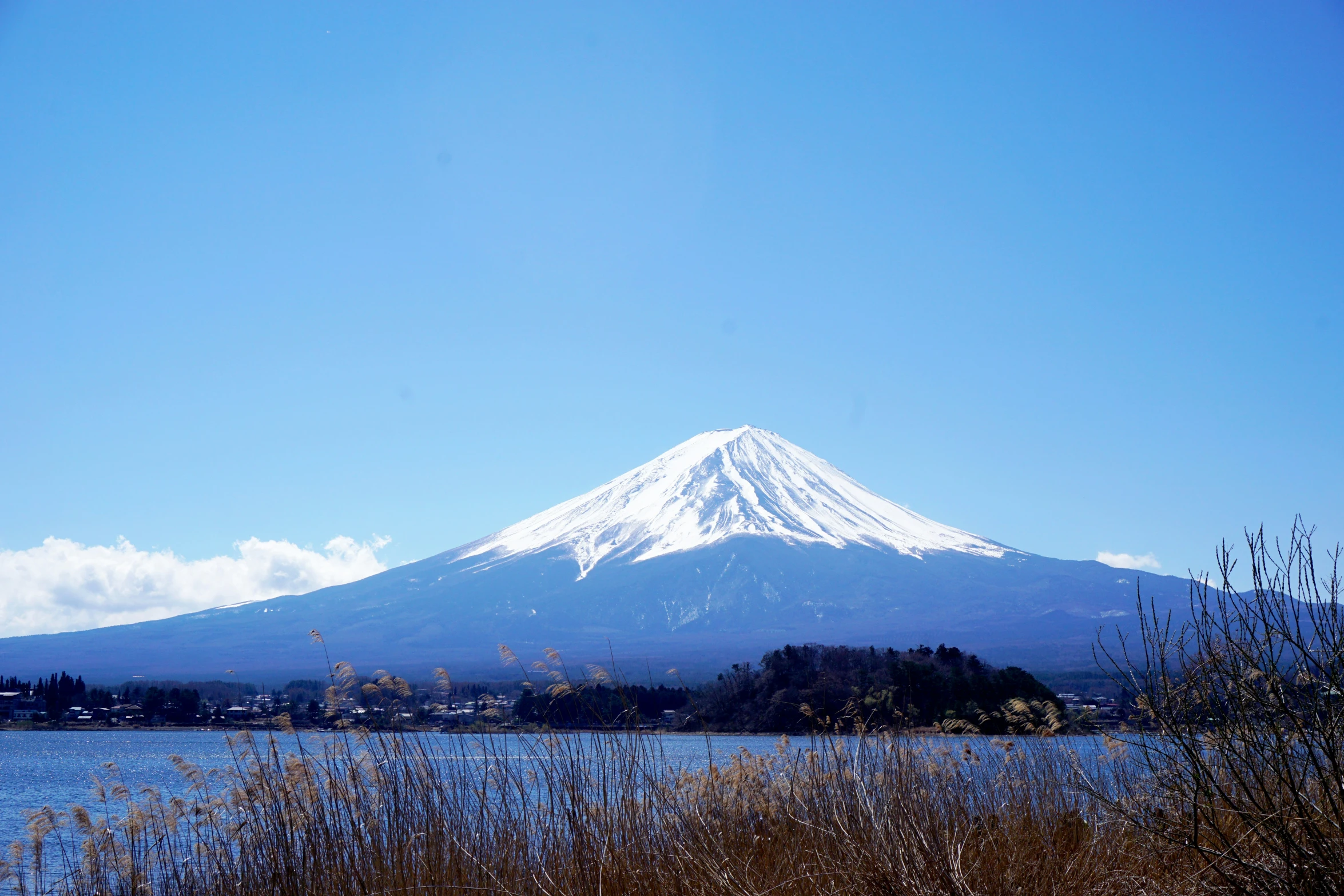 a snow covered mountain stands above the waters