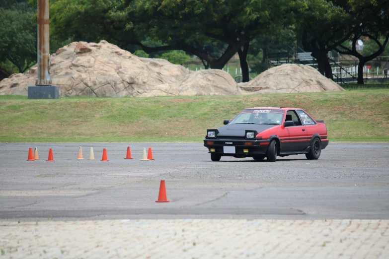 a red car is driving down the street