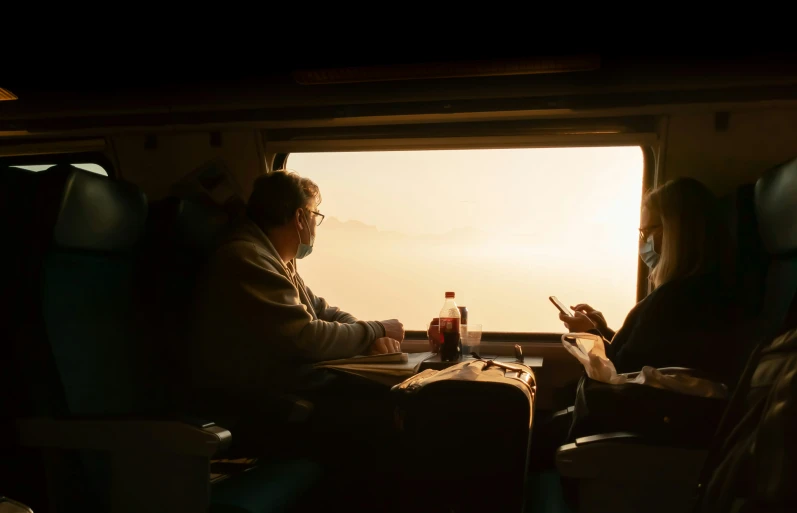 people sitting in seats with their cell phones on a train