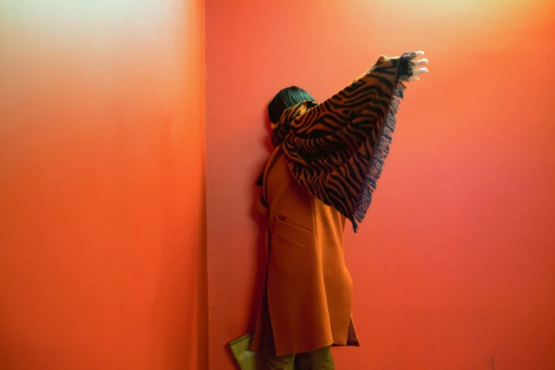 an image of woman hiding behind a wall