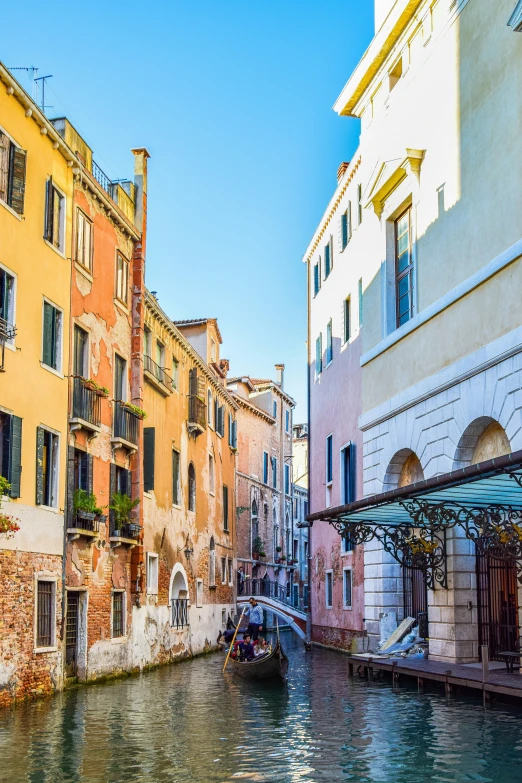 water, buildings and a small boat traveling down the canal in venice