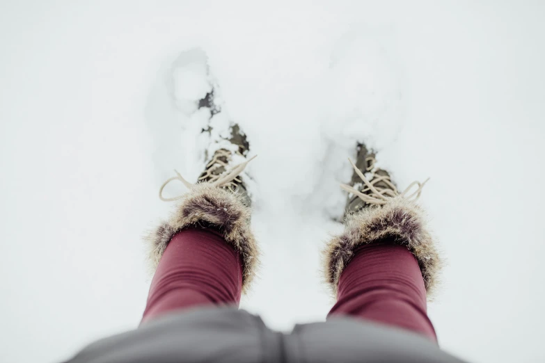 person's feet in winter gear standing on snow