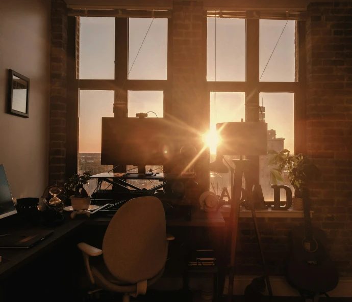 sunlight shines through two windows in a small office