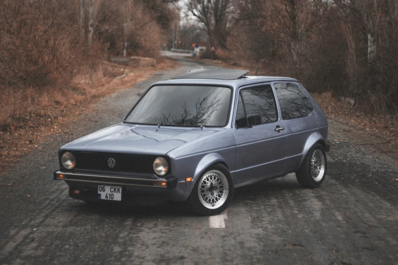 a blue volkswagen is sitting in the middle of the road