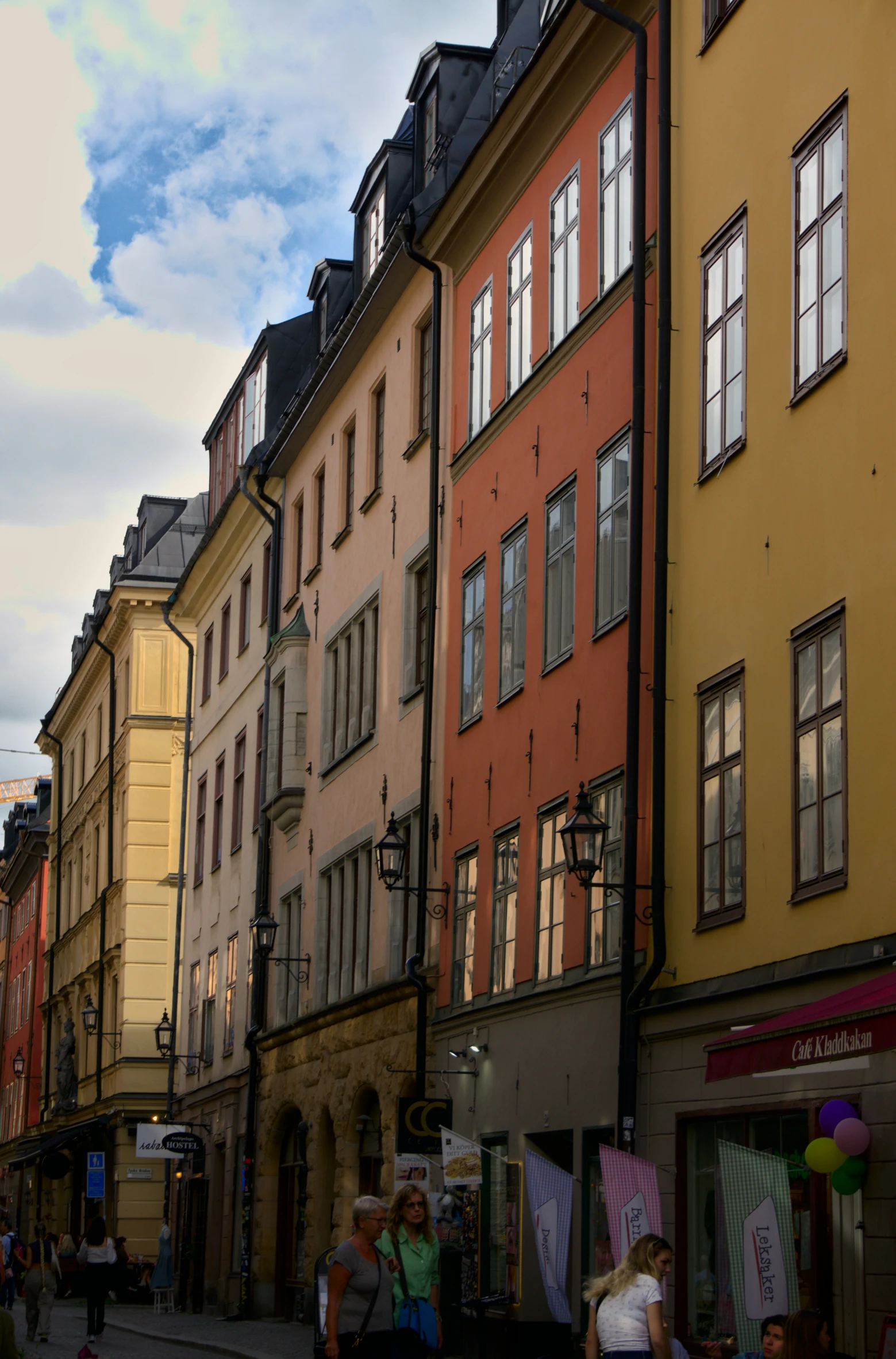 some colorful buildings and people walking down the sidewalk