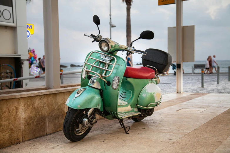 a moped parked on a sidewalk near the ocean