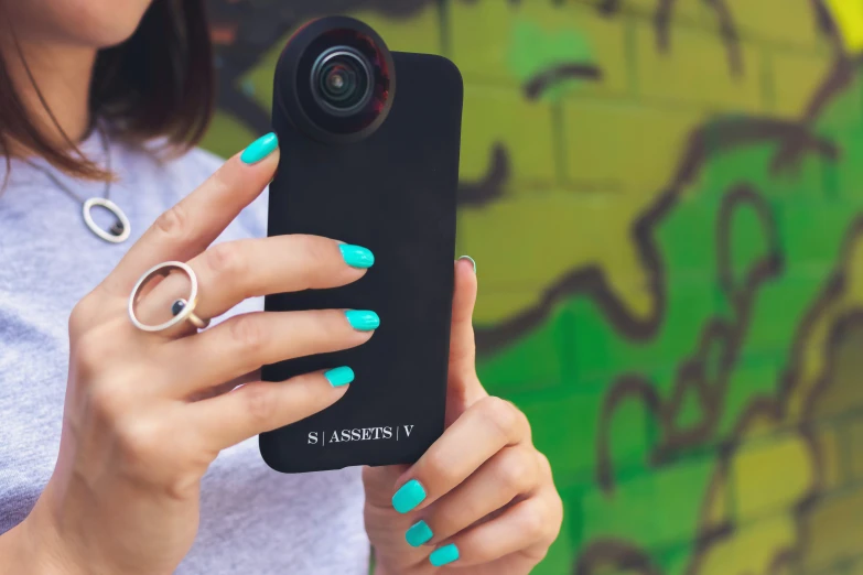 a girl wearing rings is holding up her phone