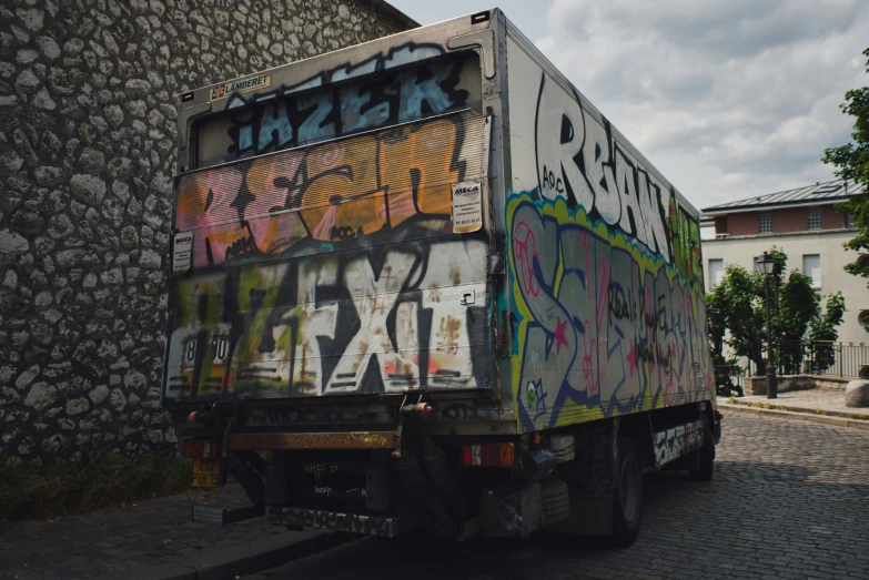 an old delivery truck with a lot of graffiti on it