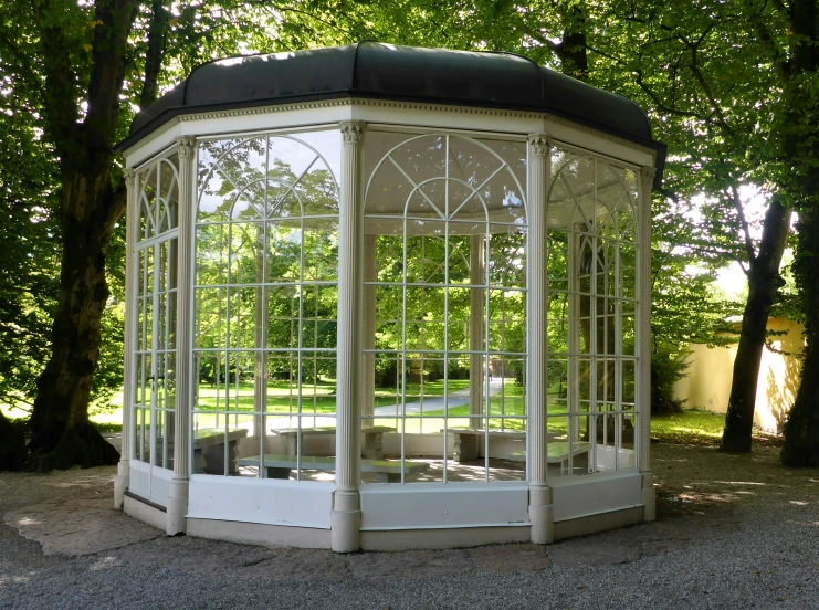 an elaborate white gazebo in a wooded area