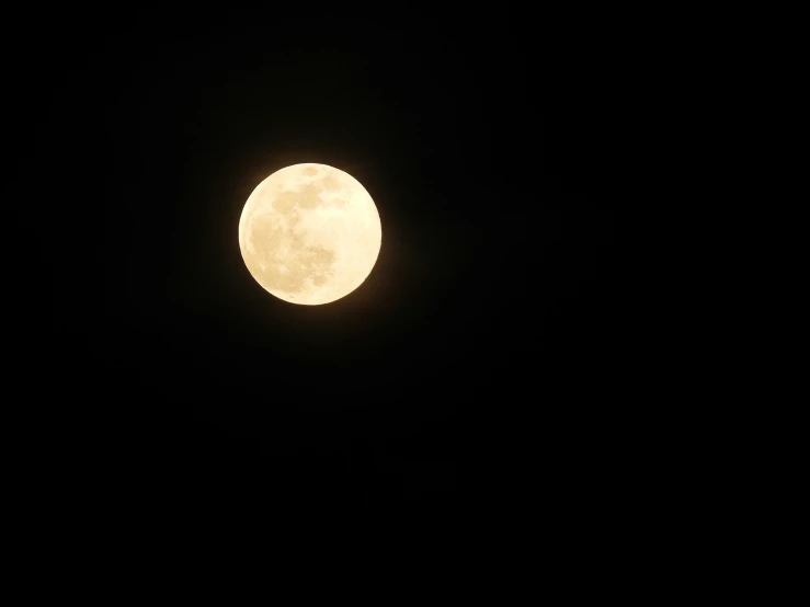a bright full moon shining over the sky