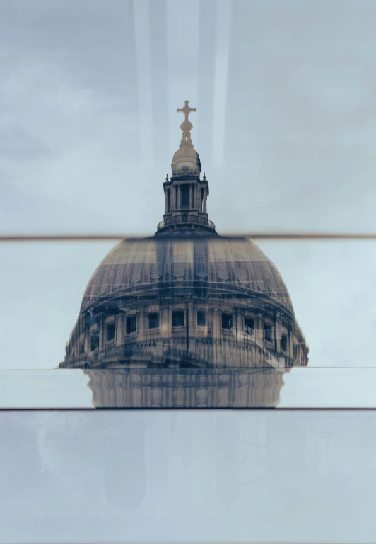 a church steeple is seen in the reflection of a glass building