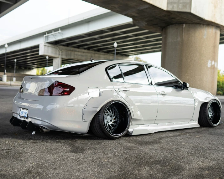 a white car parked in front of an overpass