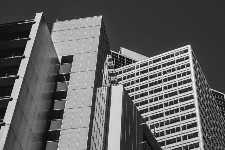 black and white picture of tall buildings in the sun