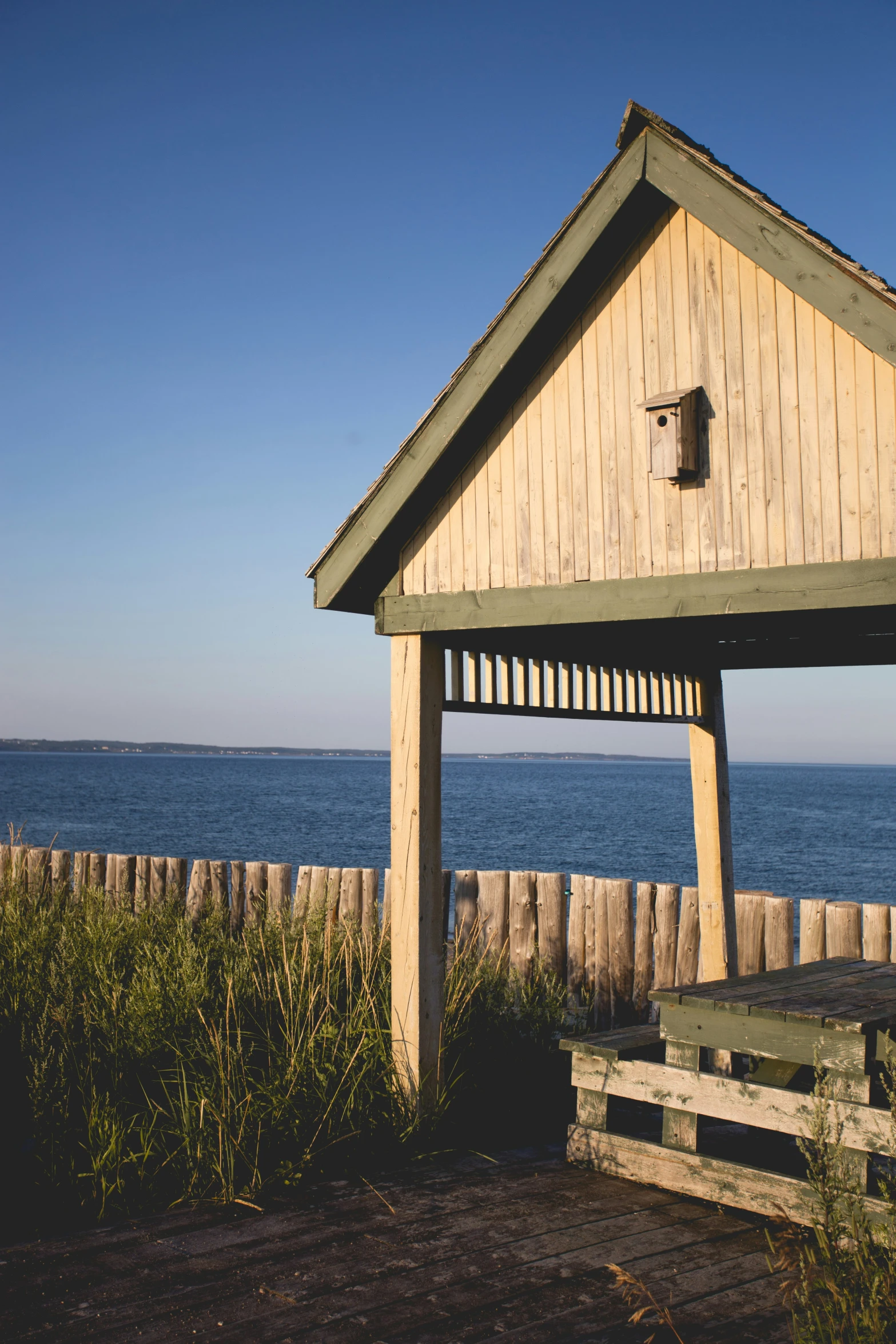 a building sitting next to the ocean with grass