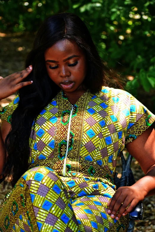 a woman in a brightly colored dress sits with her hair curled back