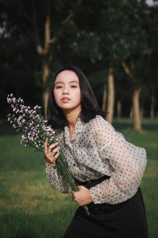 a woman holding a bunch of purple flowers