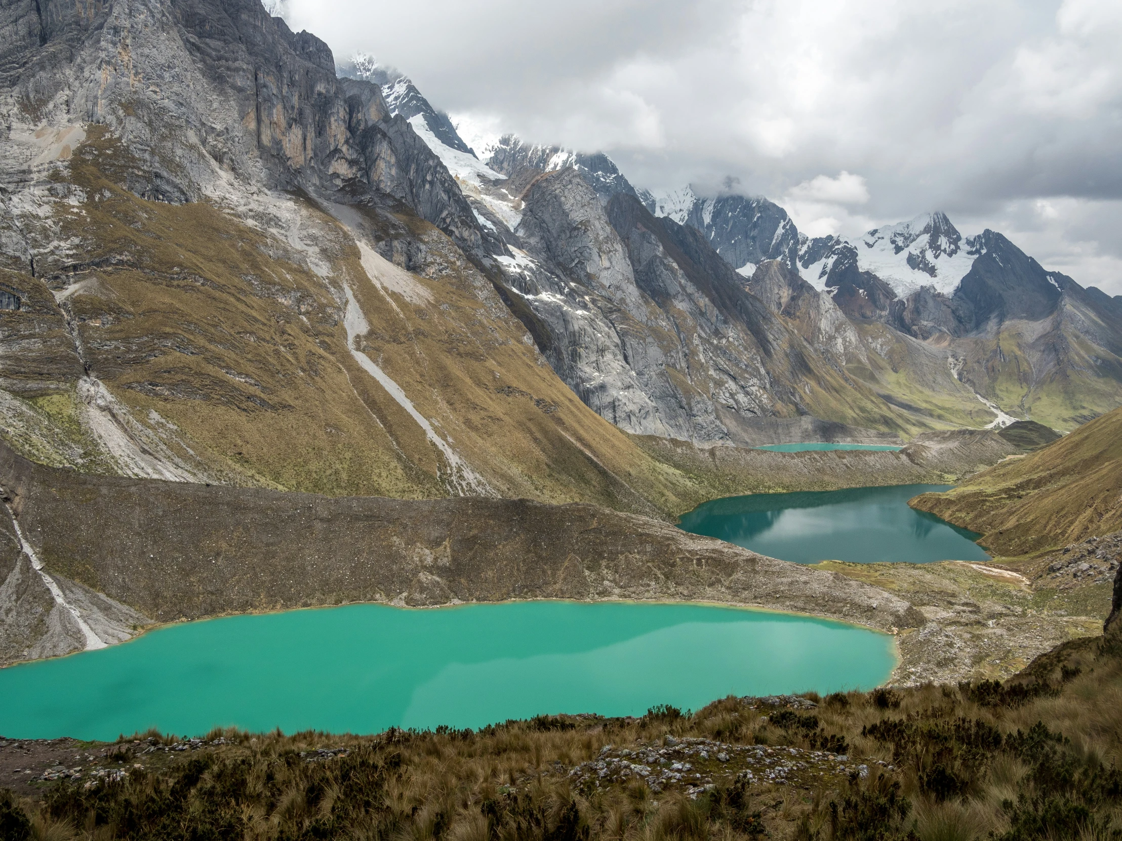 a mountain view with many lakes surrounded by grass