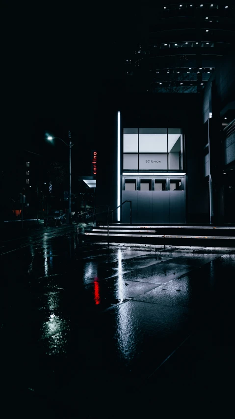 an empty dark city at night with a store front