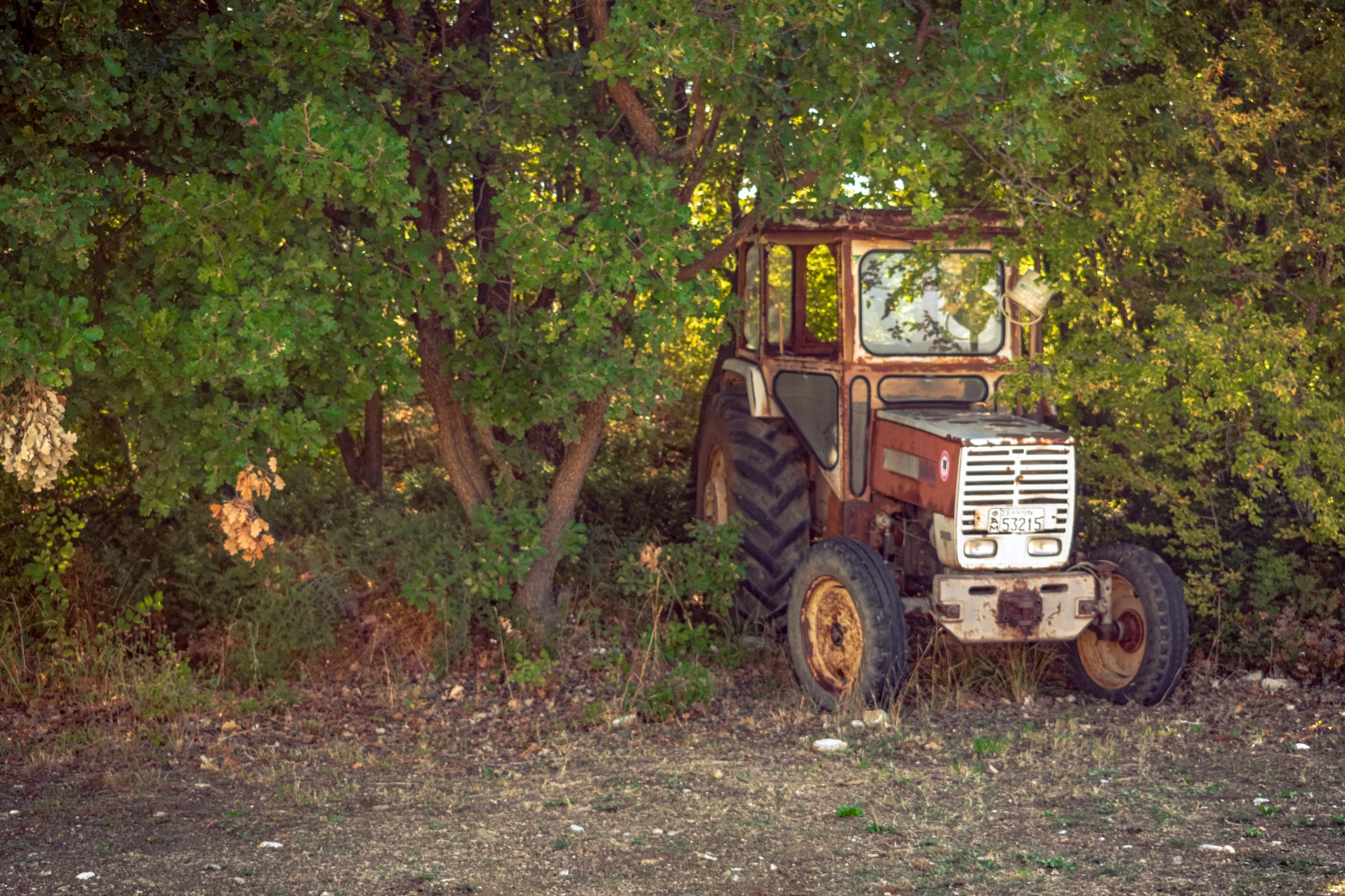 an old tractor is parked in the middle of a field