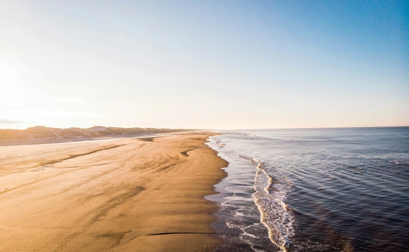 the sun shines over the ocean on a beach