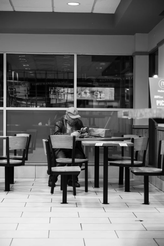 a man sitting at a restaurant with his head up eating food