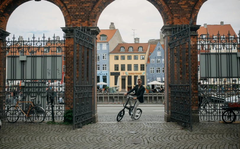 a man rides his bicycle through an arch in the town