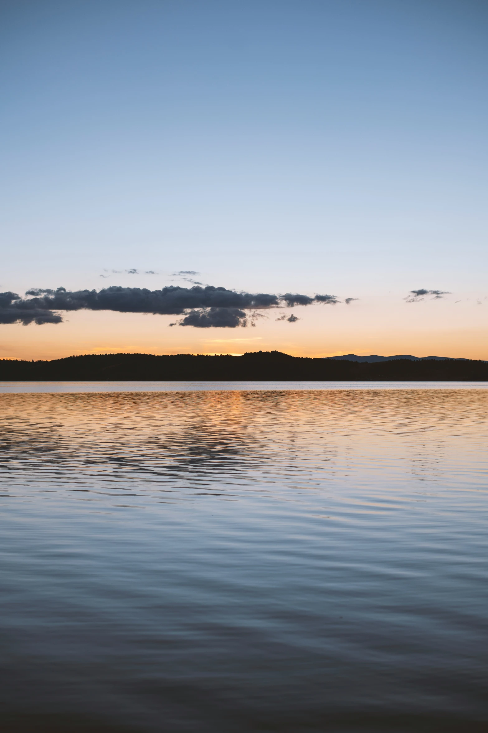 a lake during the sunset, with a boat in the foreground