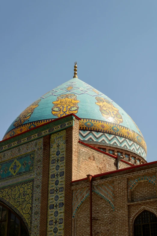 the view from below looking up at the dome of an intricate colored building