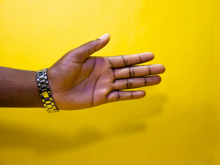 a person's hand reaches for a yellow wall