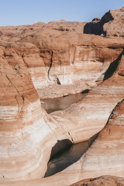 the bottom view of a canyon with small pool of water at low tide