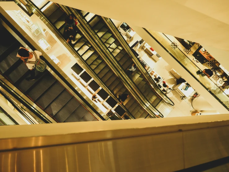 an escalator view from above of people walking up and down