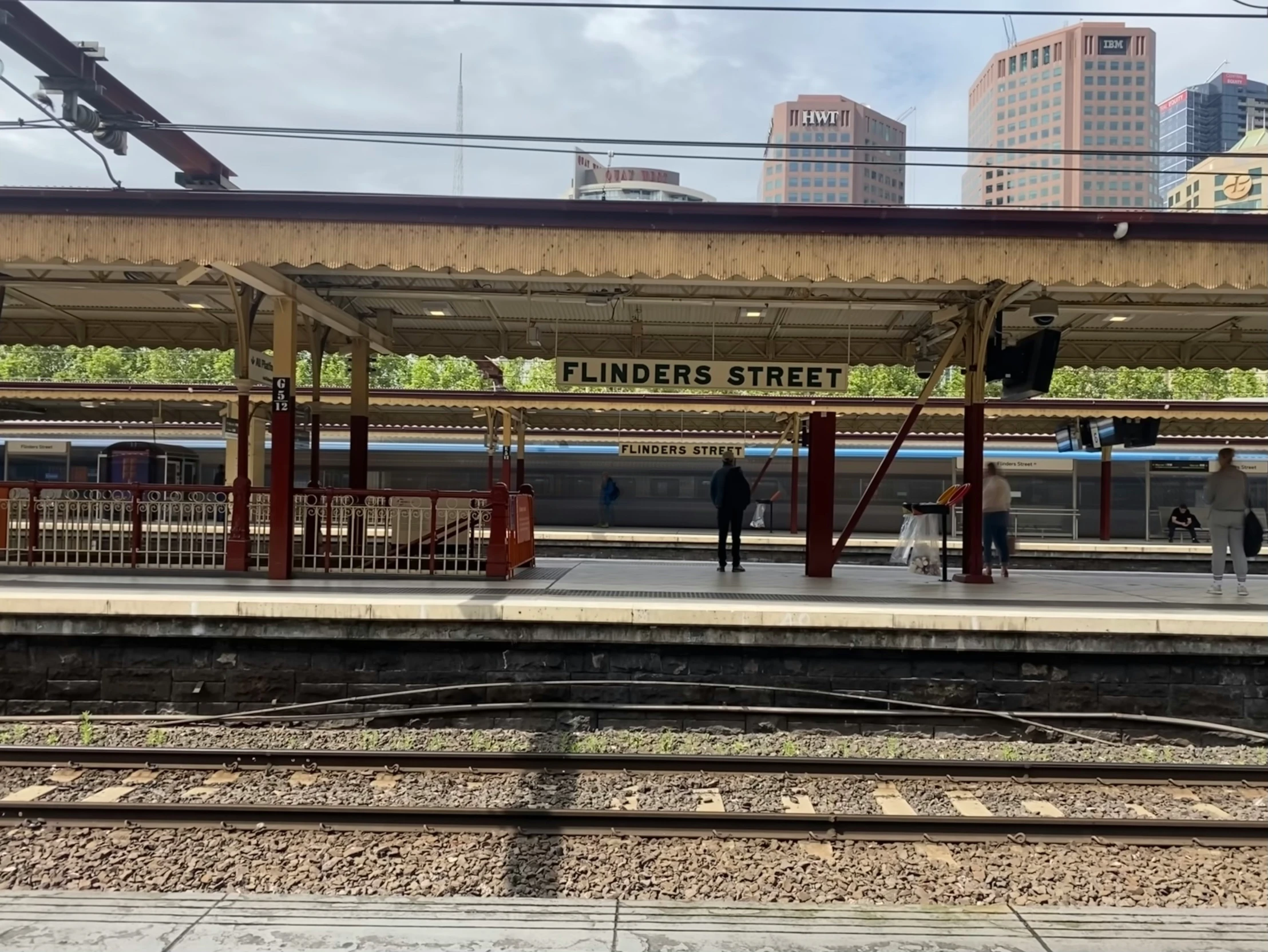 a railroad platform with a train in the distance