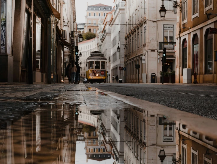 the reflection of an old style trolly in water on a wet street