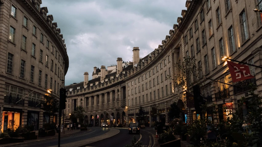 several buildings on a road at dusk with a blue sky in the background