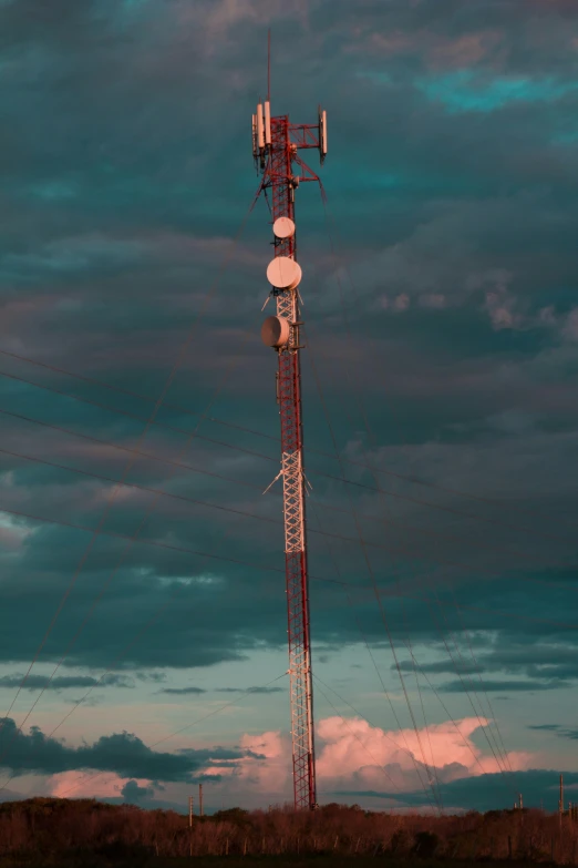 a radio tower sits beneath a dark, cloudy sky