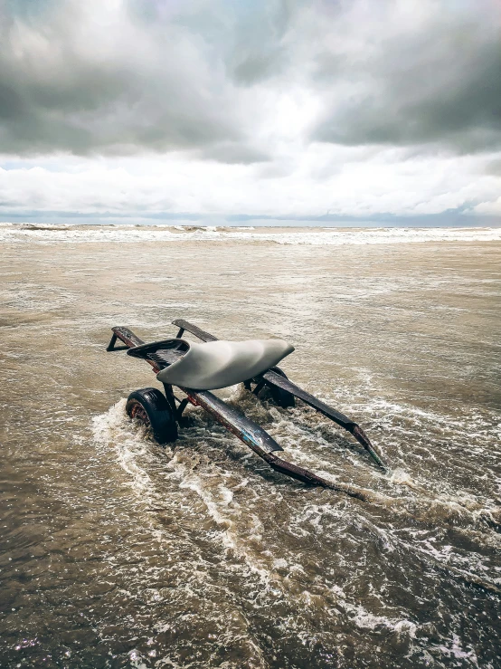 a single bike in some water on the beach